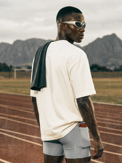 Man standing on a running track with mountains in the background